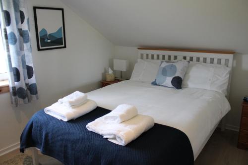 a bedroom with a bed with two towels on it at The Loft at Strathardle - Lochside Apartment, Isle of Skye in Dunvegan