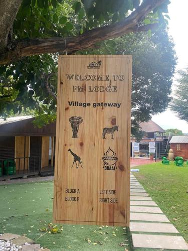 a wooden sign with animals on it in a yard at FM GUEST LODGE Comfort, Tranquility & Peace of Mind in Johannesburg