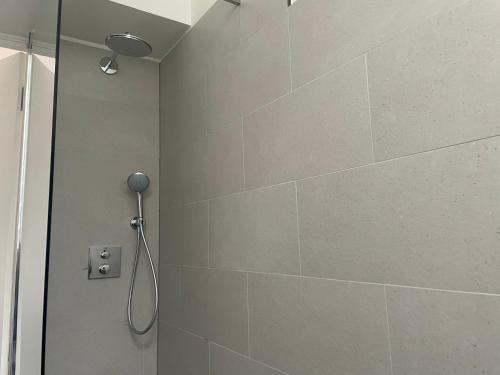 y baño con ducha y pared de azulejos. en City Hotel, en Ámsterdam