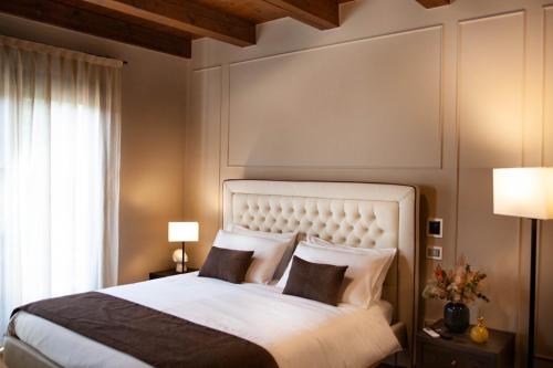 a bedroom with a large white bed with two pillows at Resort Villa Paola in Longiano