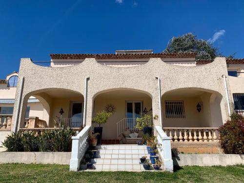 une maison avec un escalier menant à la porte d'entrée dans l'établissement Villa des Sapins, à Peymeinade