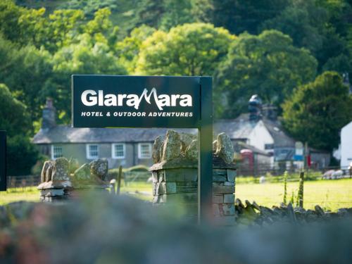 um sinal num campo com uma casa ao fundo em Glaramara Hotel em Borrowdale Valley