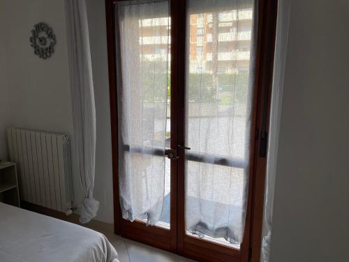 ポルト・レカナーティにあるLa casa di Murphyの窓付きのガラスドアのあるベッドルームへのドア