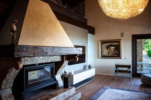 a living room with a stone fireplace and a chandelier at Resort Villa Paola in Longiano