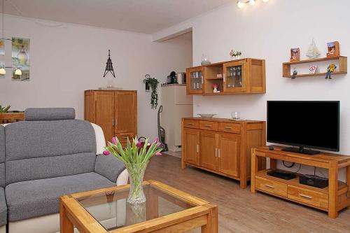 sala de estar con sofá y TV en Fischerhus _ Wohnung 3 en Cuxhaven