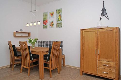 comedor con mesa de madera y sillas en Fischerhus _ Wohnung 3 en Cuxhaven