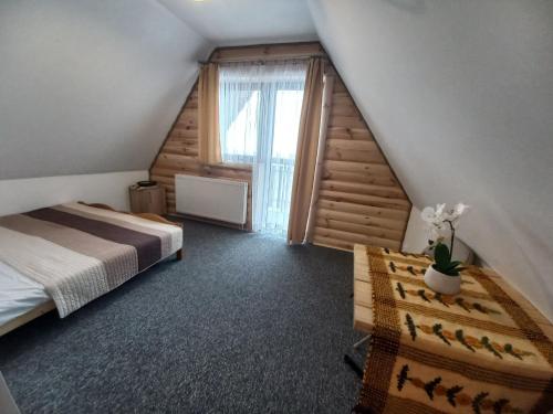 a attic bedroom with a bed and a window at Niebiańska Grań in Zakopane