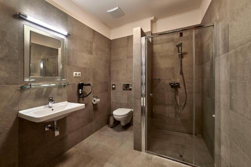 a bathroom with a shower and a sink and a toilet at Penzión Skalica in Skalica