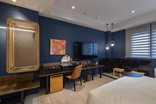 a bedroom with a bed and a desk and a tv at 墾丁耳東華苑ErDong Manor in Kenting