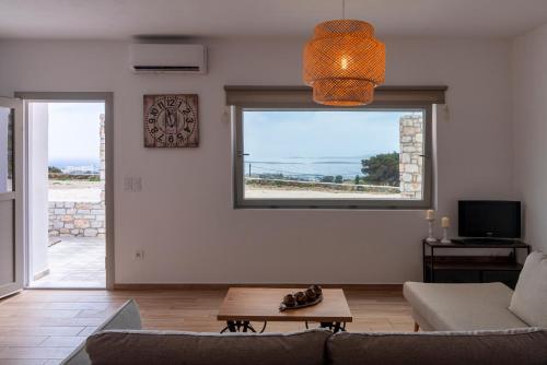 a living room with a couch and a table and a window at Panteronisia View Villa in Angairiá