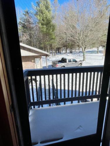 a snow covered balcony with a car in a parking lot at Lodges at Buffalo Mountain- 168 private acres in Floyd