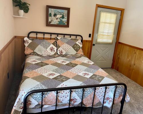 a bedroom with a bed with a quilt on it at Lodges at Buffalo Mountain- 168 private acres in Floyd