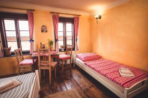 a bedroom with a bed and a table and chairs at Pension Cert a Kaca in Český Krumlov