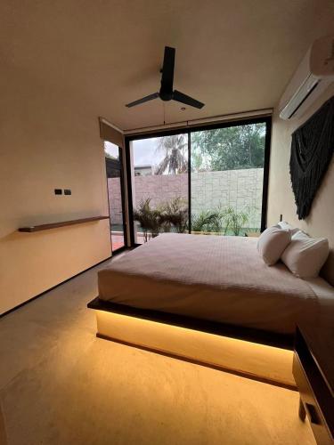 a bedroom with a large bed and a large window at La Veleta luxury condos in Tulum