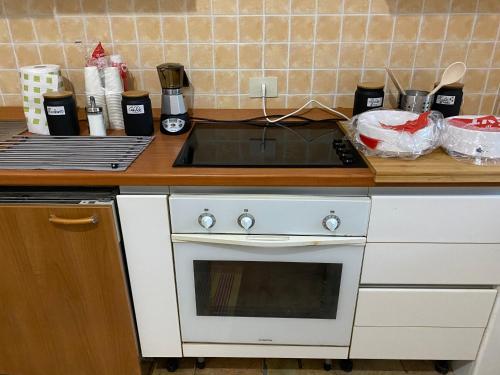a kitchen counter with a stove and a sink at Casale Colle dei Pini in Casaccia