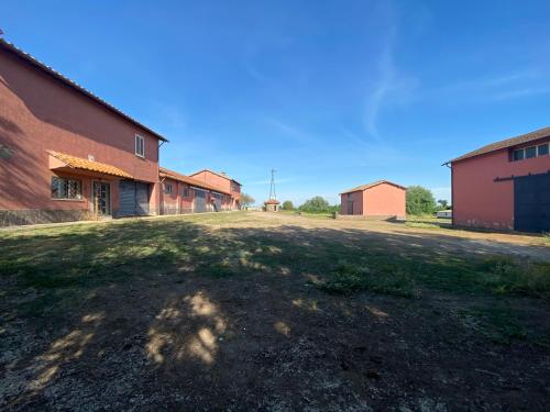 an empty field next to a brick building at Casale Colle dei Pini in Casaccia