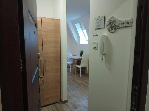 un corridoio con porta e una sala da pranzo con tavolo di Szellőrózsa Apartman a Fonyód