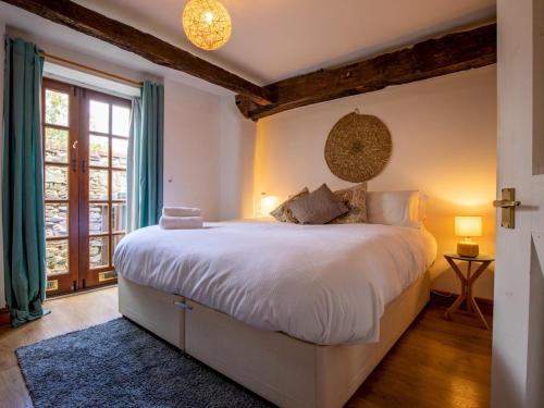 una camera da letto con un grande letto bianco e una finestra di Pass the Keys Quaint 1 bedroom cottage in Church Stretton a Church Stretton
