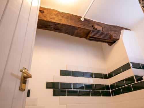 een balkenplafond in een badkamer met groene tegels bij Pass the Keys Quaint 1 bedroom cottage in Church Stretton in Church Stretton