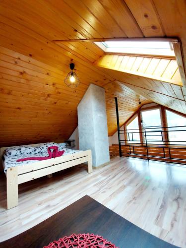 a room with a bed in a wooden ceiling at Domki pod Bukowym lasem in Wańkowa