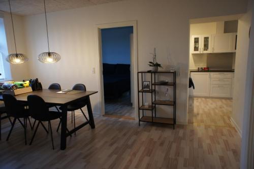 a dining room with a table and chairs and a kitchen at 87 Østergade (id. 051) in Esbjerg