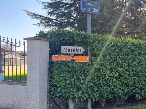 a street sign in front of a bush at Villa Géna in Saint-Médard-dʼEyrans
