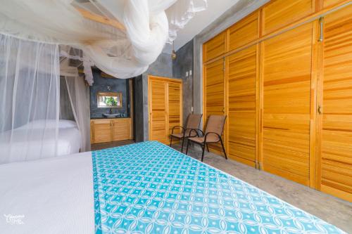 a bedroom with a bed and wooden cabinets at Casa de la Gente Nube in Puerto Escondido
