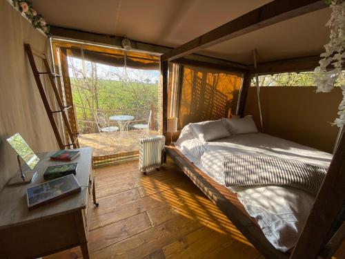 a bedroom with a bed and a table and a window at Beautiful Lakeside Safari Lodge in Bruton