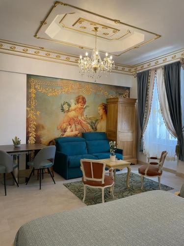 a living room with a blue couch and a painting at Chambre Familiale Maison de L'Église du Couvent in Narbonne