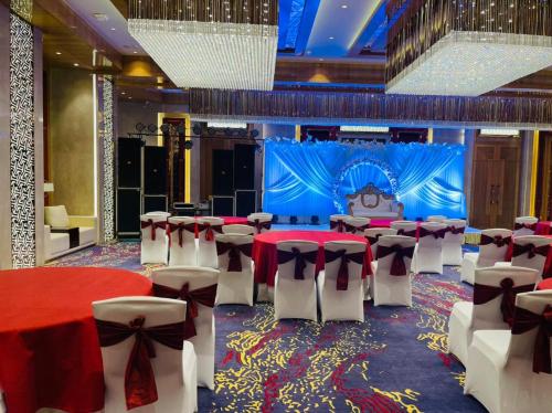 un salón de banquetes con mesas y sillas rojas y blancas en Best Western Vrindavan en Vrindāvan