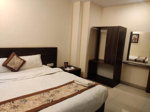 a bedroom with a bed and a mirror at Hotel The Narayani Continental in Gangtok
