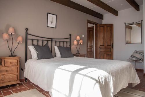 um quarto com uma grande cama branca e uma cadeira em Villa Morera Garden Villa 5 pers, 2 bedrooms with extra rooms when needed em Frigiliana