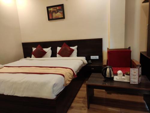 a bedroom with a large bed with red pillows at Hotel The Narayani Continental in Gangtok