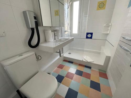 a bathroom with a toilet and a sink at Hôtel Le Mirage in Saintes-Maries-de-la-Mer