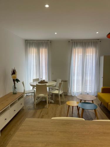 uma sala de estar com uma mesa e um sofá amarelo em Estrada Suites em Ávila
