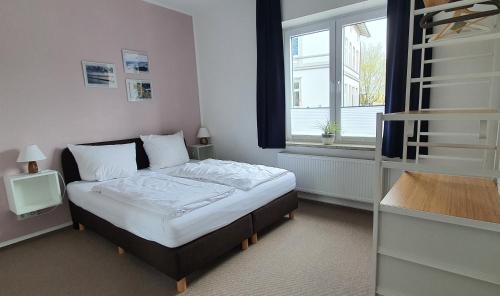 a small bedroom with a bed and a window at Gästehaus bed & kitchen in Schleswig