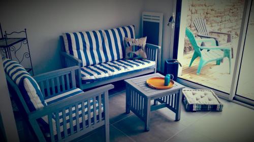 プロムールにあるTY Maelouの青と白の椅子とテーブルが備わる客室です。