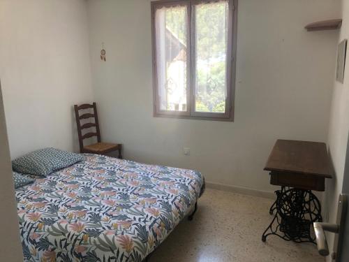 une chambre avec un lit, un bureau et une fenêtre dans l'établissement Maison au calme avec parking en petite Camargue, à Beauvoisin