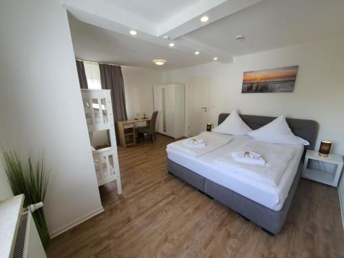 Schlafzimmer mit einem großen weißen Bett und einem Schreibtisch in der Unterkunft Das SP Hotel in Fürth