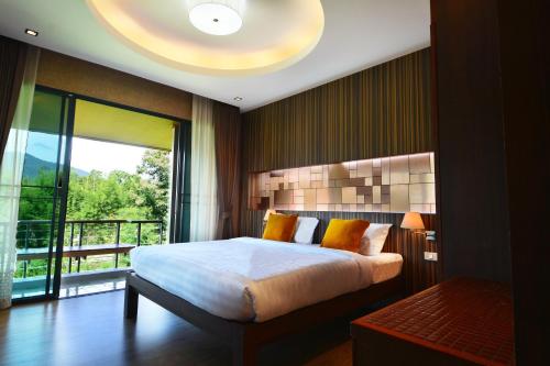 a bedroom with a large bed and a large window at Burapa Boutique in Chiang Mai