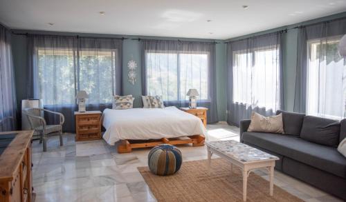 sala de estar con cama y sofá en Villa Morera Bed & Breakfast, en Frigiliana