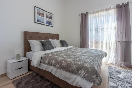 ein Schlafzimmer mit einem großen Bett und einem Fenster in der Unterkunft Apartment Villa Sea Star in Kastav