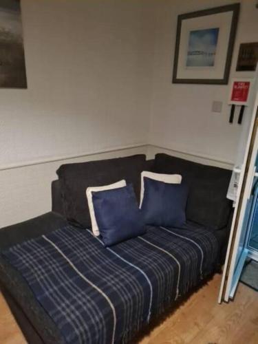 un divano nero con cuscini blu in una stanza di SQUIRRELSTONE a Gurnard