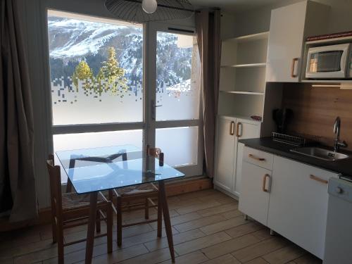 梅里貝勒的住宿－Résidence Alpinéa Mottaret, 3 à 5pers，厨房在窗户前配有桌子