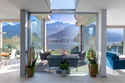a patio with a view of a lake and mountains at Villa Costanza- private seasonal warm pool, steam room, sauna-Bellagio Village Residence in Oliveto Lario