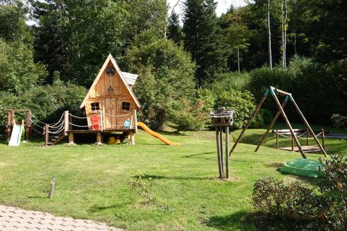 een speelplaats met een huis en een speeltuin bij Le Kota Etable in La Chapelle