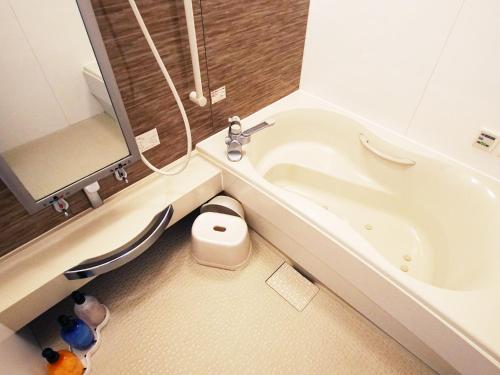 La salle de bains est pourvue de toilettes et d'une baignoire. dans l'établissement Mariage Leisure Hotel, à Tsukuba