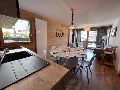 une cuisine et une salle à manger avec une table et des chaises dans l'établissement Elan 12 - Très bel appartement centre village, à La Clusaz