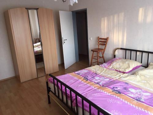 ein Schlafzimmer mit einem Bett mit einer lila Bettdecke in der Unterkunft 3-Zimmer Ferienwohnung nähe Darmstadt in Roßdorf