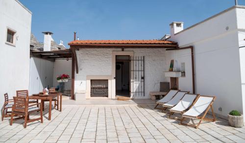 a patio with chairs and a table and a building at Dimora Aia Piccola in Alberobello